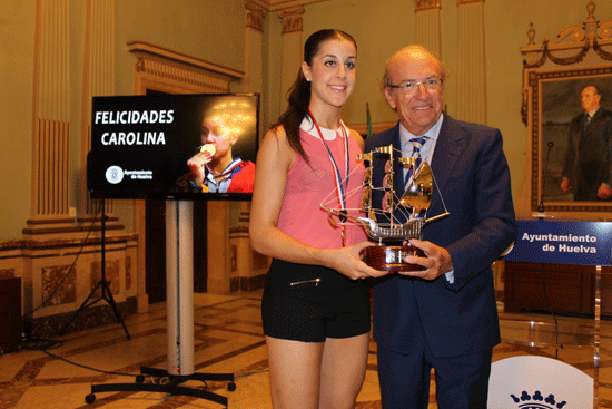 El alcalde de Huelva, Pedro Rodríguez hace entrega de un presente a la campeona del mundo de bádminton, Carolina Marín.