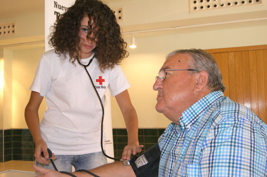 Una voluntaria de Cruz Roja toma biomedidas a una persona.