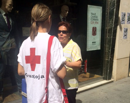 Una voluntaria de Cruz Roja informa del Sorteo del Oro de Cruz Roja.