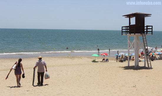 Turistas llegan a la Playa Central de Isla Cristina.